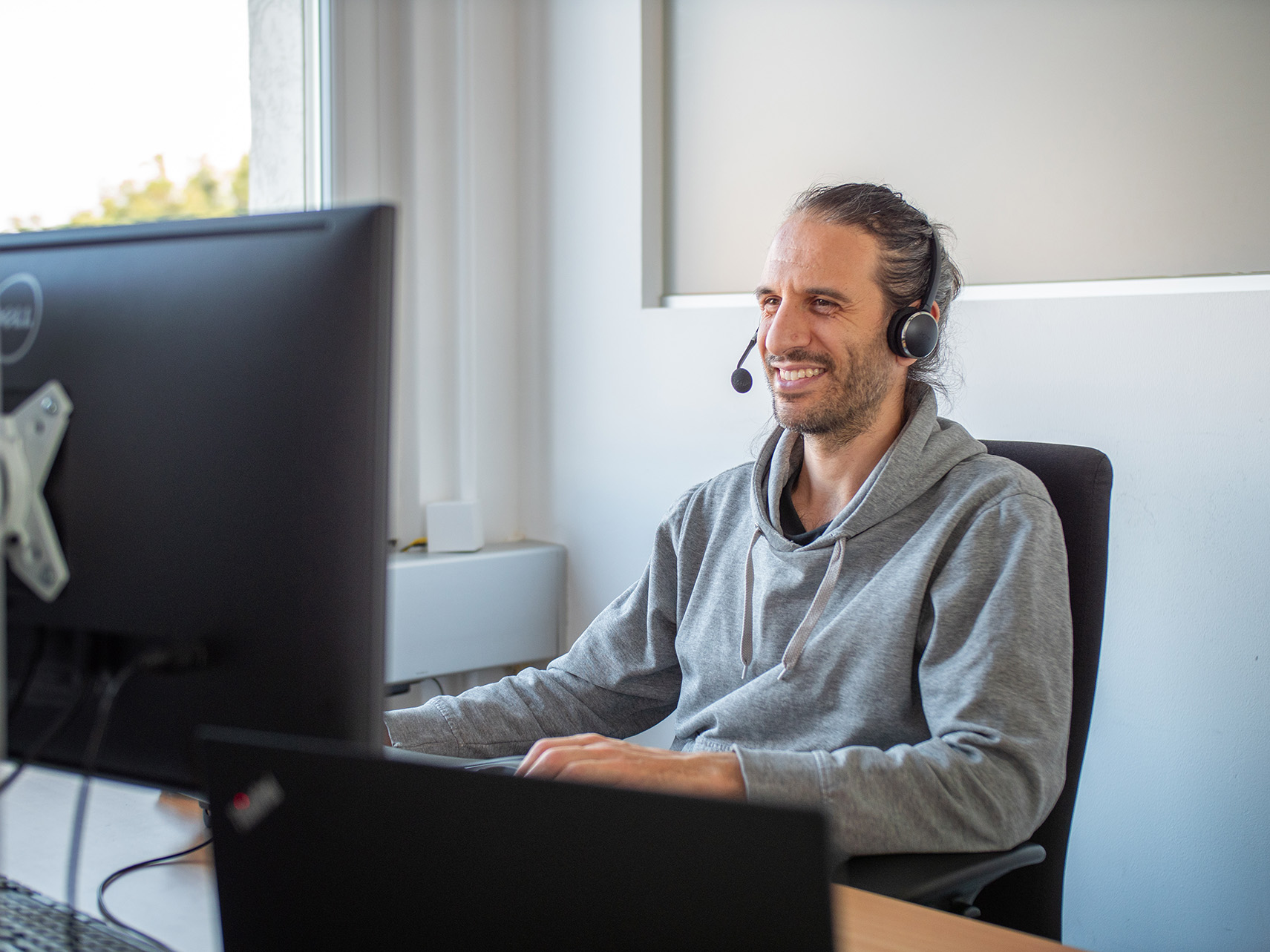 Person mit Kopfhörer vor PC