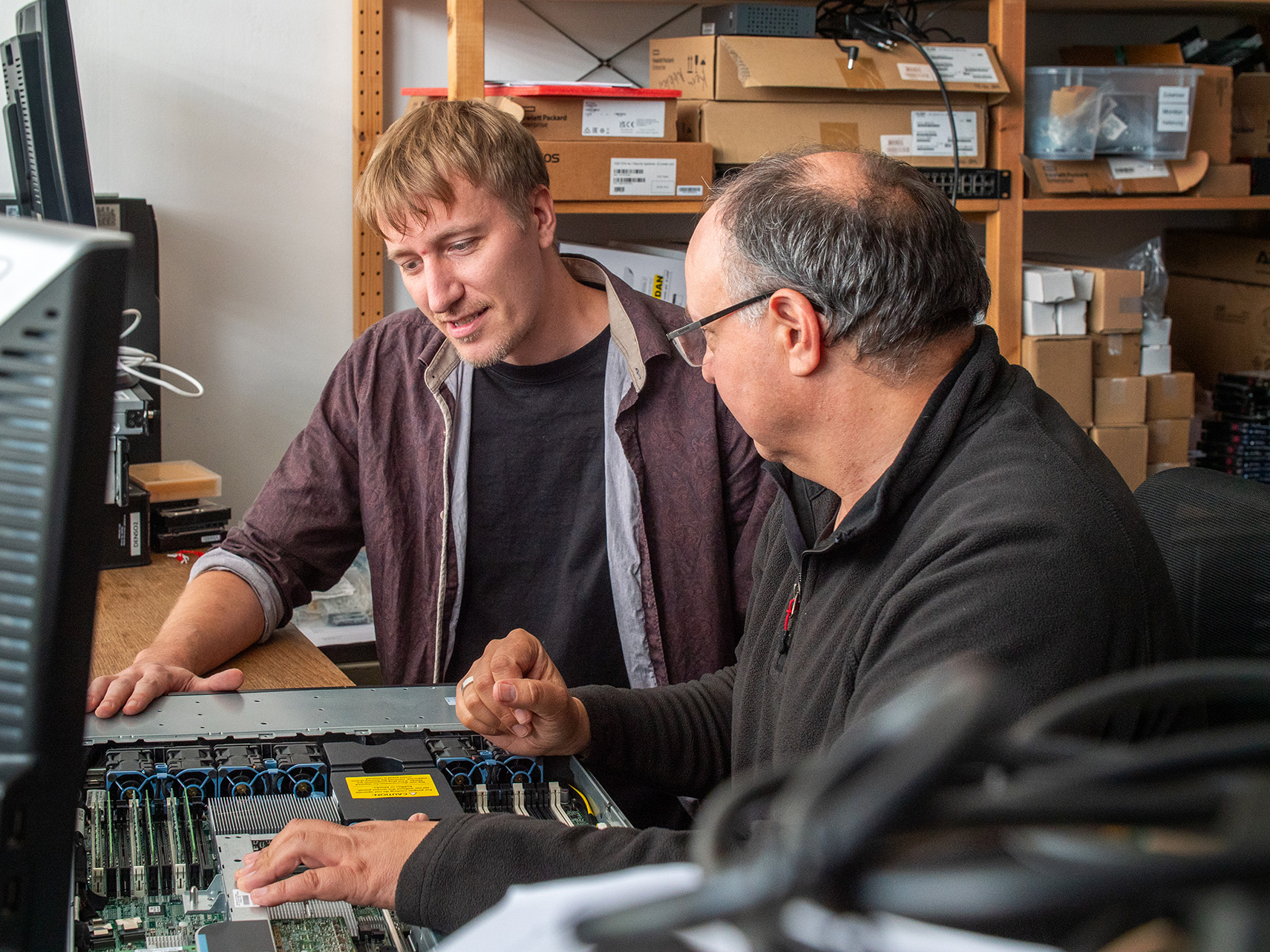 2 Personen über offenen Server gebeugt